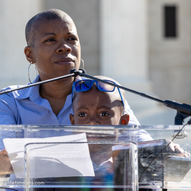 Photo of Stacey Stevenson with son, London, speaking in front of the Supreme Court.